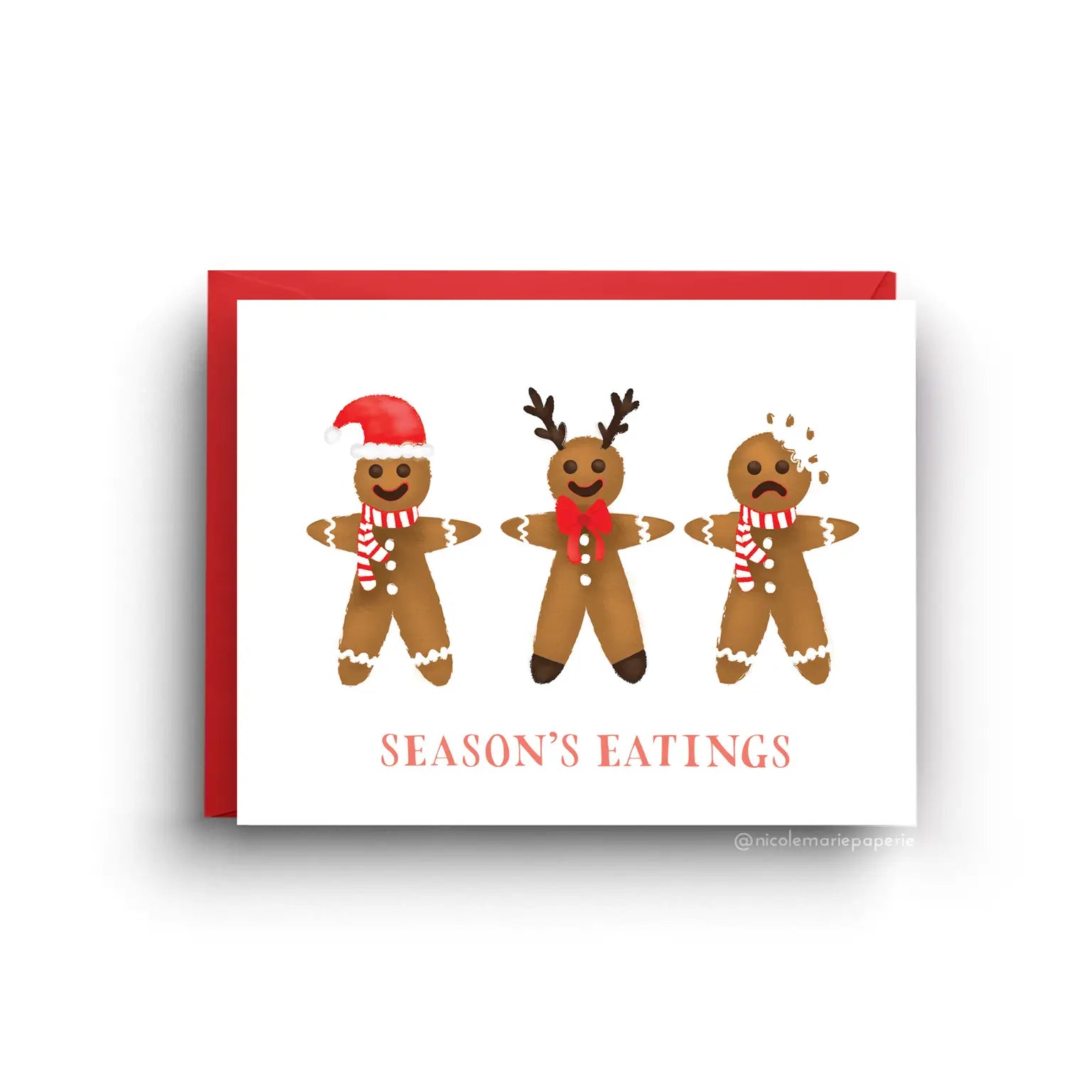 White card with three gingerbread cookies. Two are smiling and one is frowning with a bite taken out of its head. Orange text reads "season's eatings" 