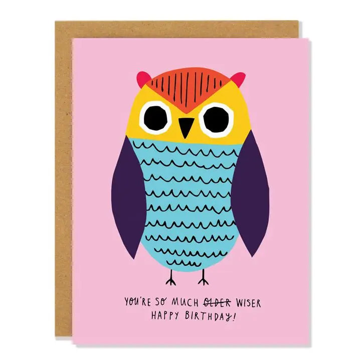 Pink card with orange, yellow, blue, and purple owl illustration. Black text reads "you're so much  older wiser. Happy birthday!" Older is crossed out. Inside of card is white. 