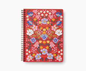 Cover of a red notebook with pink, blue, yellow, and white flowers. 