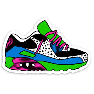 Sneaker shaped sticker. Sneaker is green, black, white, pink, and blue and has pink shoelaces. 