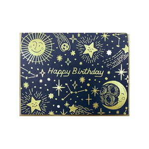 White card with black background and gold stars, suns, and moons. Gold text reads "happy birthday"