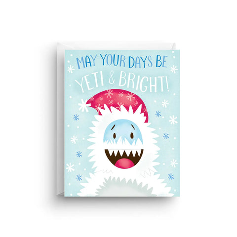 White card with light blue background and illustration of a white yeti wearing a red hat. Blue text reads "may your days be" and white text reads "yeti and bright" 