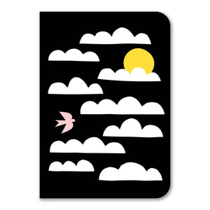 The notebook cover is a black background with white clouds, a yellow sun, and a light pink bird. 