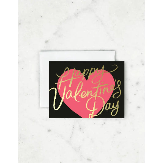 White greeting card with full color black background. Pink heart. Gold script reads "happy valentine's day" 