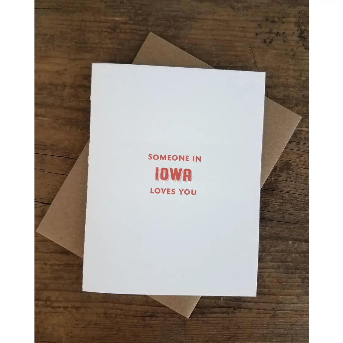 White card with red text reading "someone in Iowa loves you"