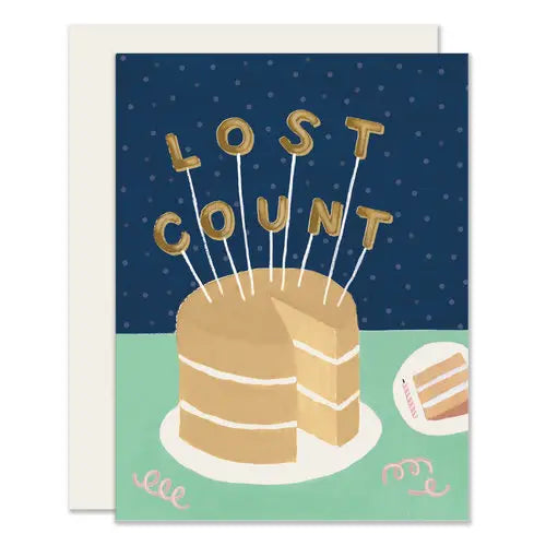 White card with navy and mint green background. Brown cake with gold candles that spell out "lost count"