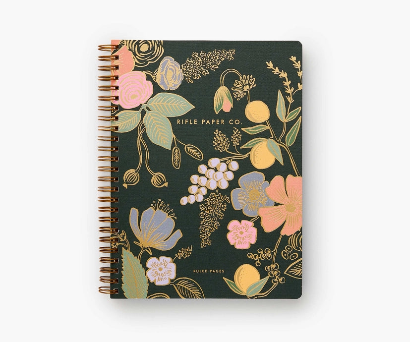 Dark green notebook cover with light green, pink, gold, and blue flowers. 