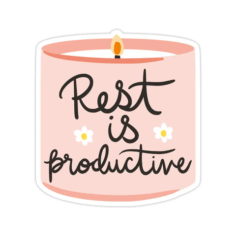 Die-cut sticker in the shape of a candle. Pink background and black text reading "rest is productive" 