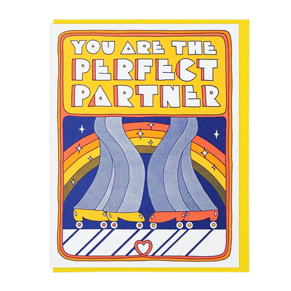White card with illustration of two pairs of jeans and roller skates. Yellow box with white block letters inside spelling out "you are the perfect partner" 