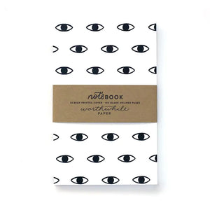 Blank white notebook. Cover features a repeating eye pattern in black ink. 