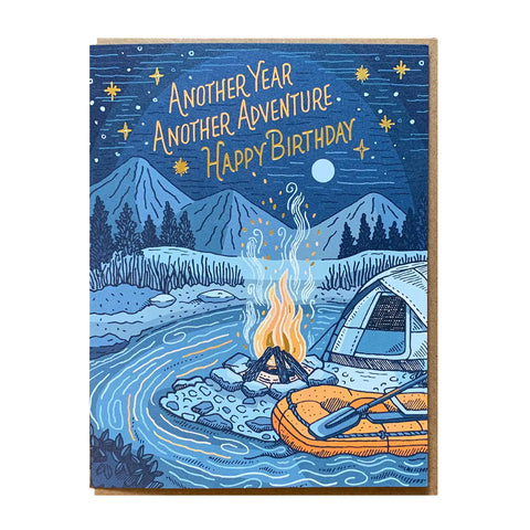 White card with blue starry night background, including a tent and orange fire and kayak. Gold text reads "another year, another adventure, happy birthday"
